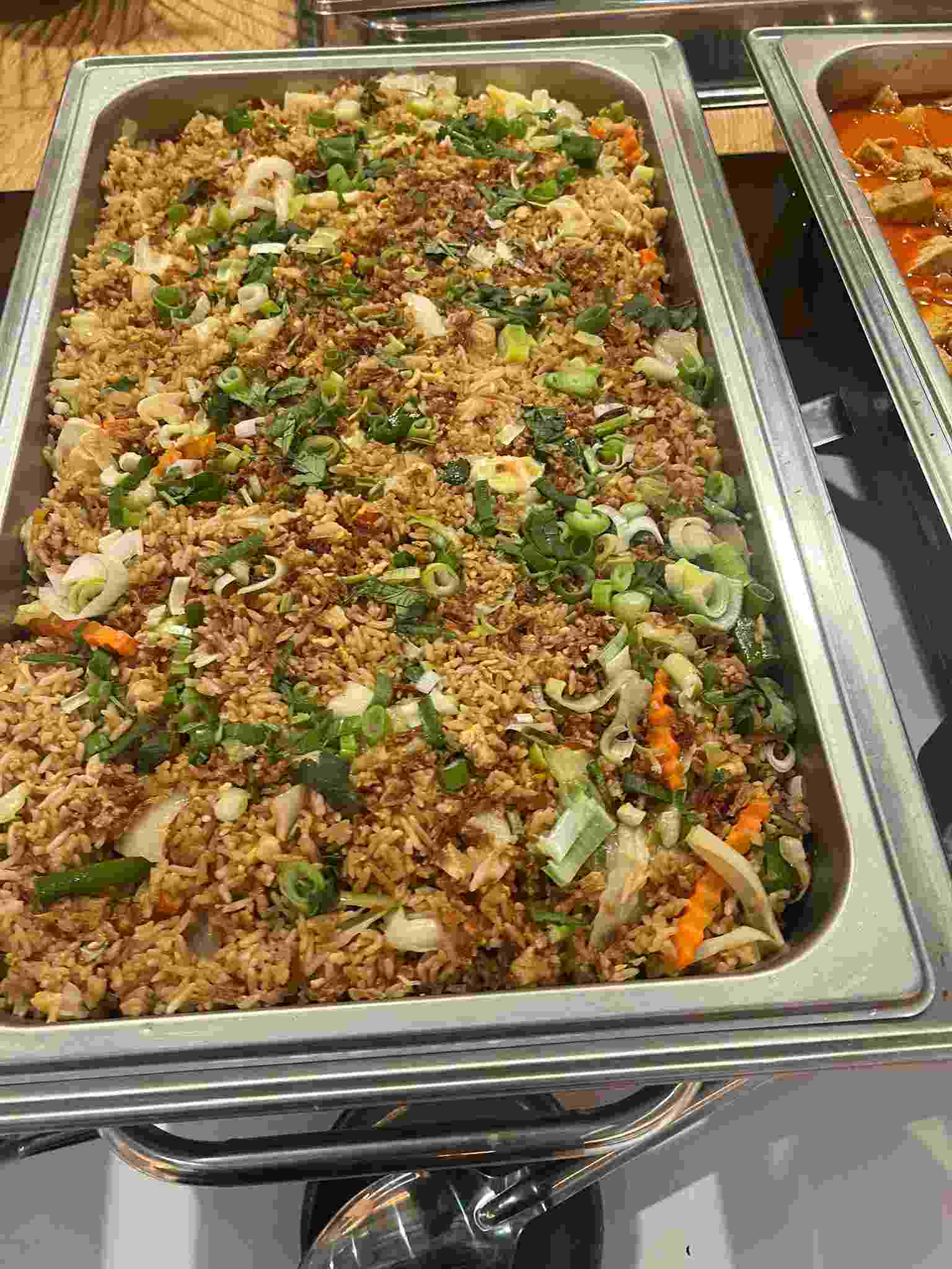 Thai fried rice with vegetables, spring onion and coriander in a catering tray