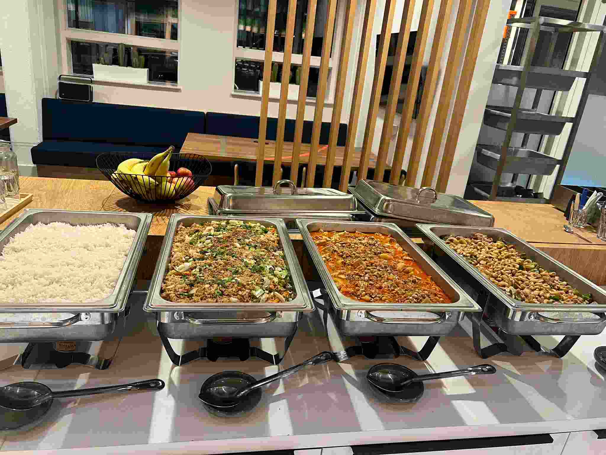 Royal Thai catering buffet set up in chafing dishes with jasmine rice, Thai fried rice, Massaman curry and cashew nut stir-fry